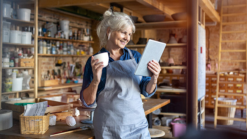 Women smiling at her tablet in her studio